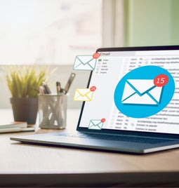 Laptop open with inbox receiving emails