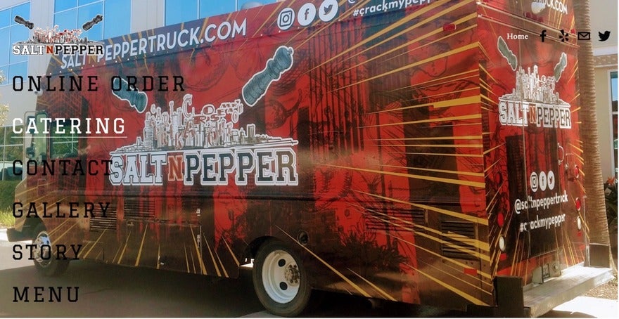 A Salt N' Pepper food truck parked in front of a building in London, UK on Wednesday, December 6, 2023. The truck is white with a red and black logo. The text on the truck says "SALT N' PEPPER | Southern California Food Truck" and "SALTINPEPPER.COM."
