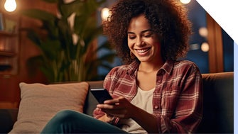 Woman smiles at her cell phone while relaxing